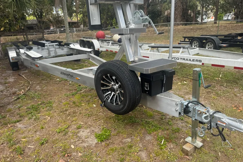 Slide: The Image of Trailer for 2026 Costa Custom Boats 264 HC, parked on grass with spare tire. - 63