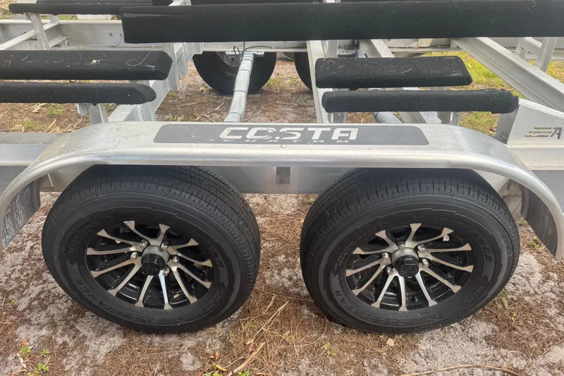 Slide: The Image of Trailer for 2026 Costa Custom Boats 264 HC with dual black alloy wheels. - 64