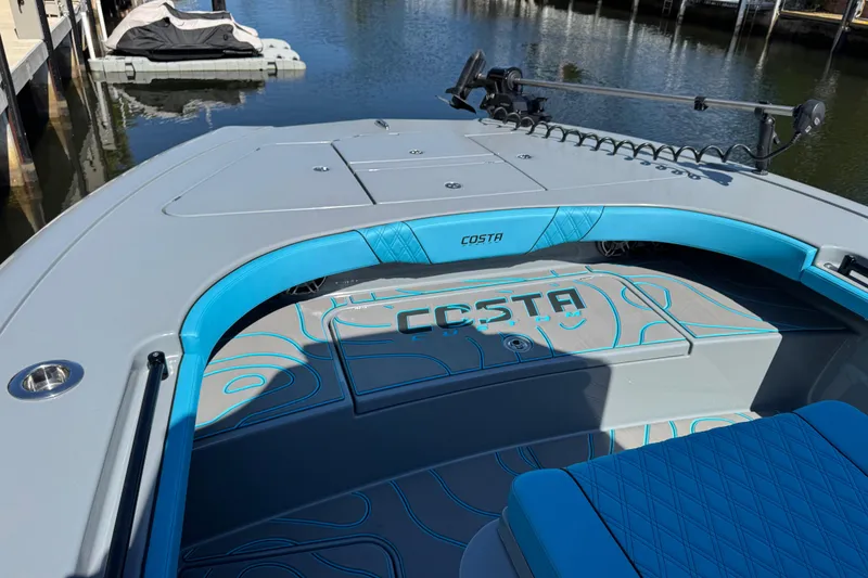 Slide: The Image of 2026 Costa Custom Boats 264 HC, sleek design, blue accents, docked on calm water. - 7