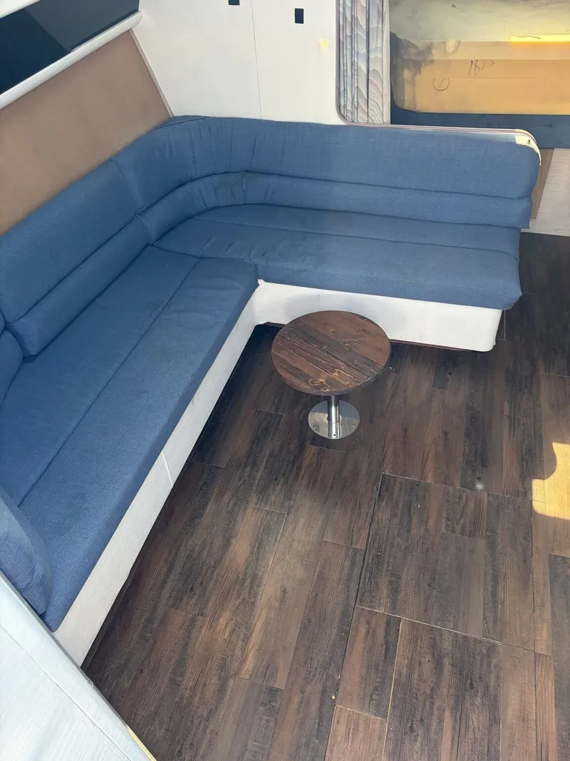 Slide: The Image of Interior of a 1988 Silverton 34X with blue couch and wooden floor. - 11