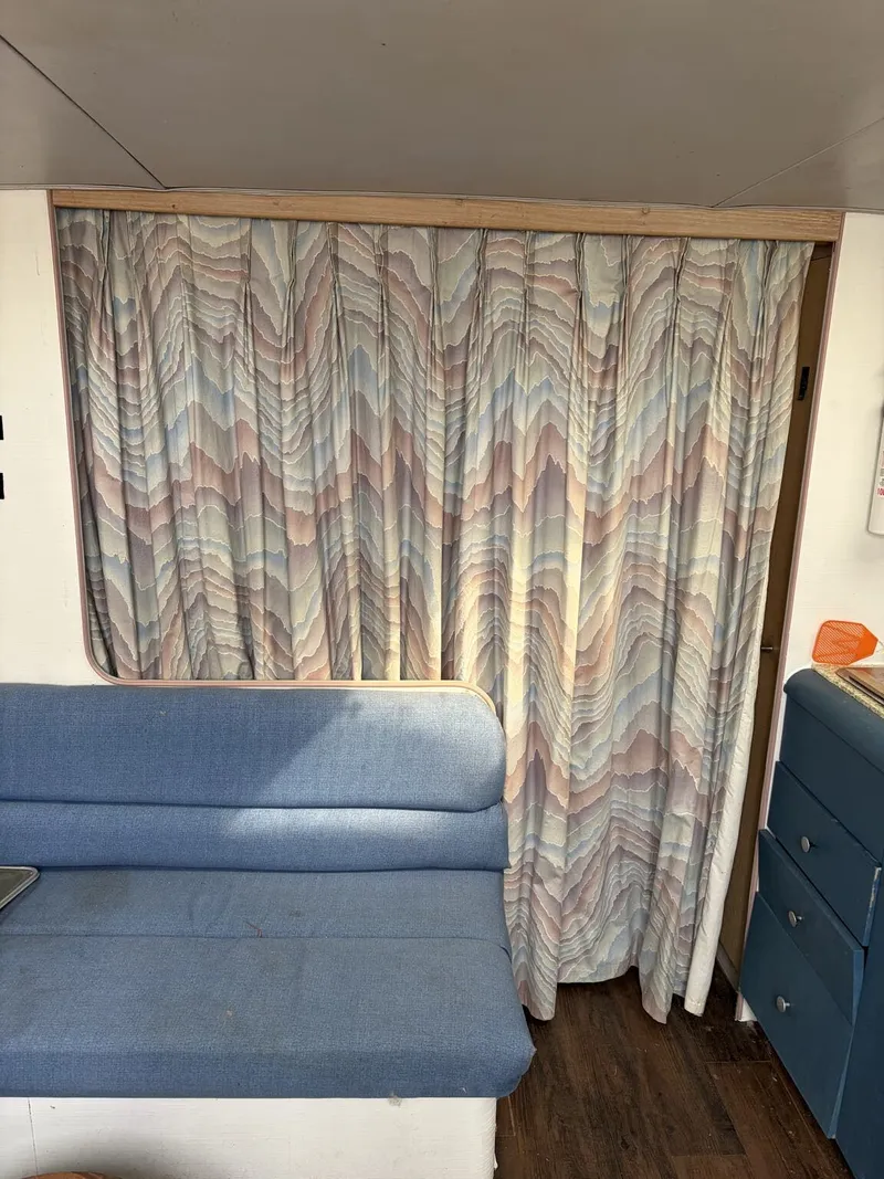 Slide: The Image of Interior of 1988 Silverton 34X with blue couch and patterned curtains. - 6