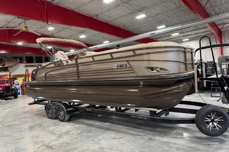 The Image of 2015 Sun Tracker Regency 254 XP3 pontoon boat on trailer in indoor showroom. - 1