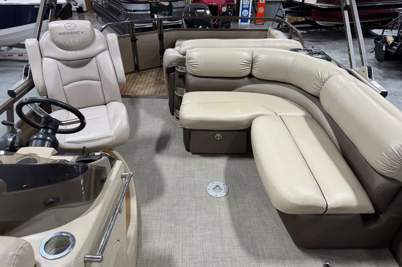 Slide: The Image of 2015 Sun Tracker Regency 254 XP3 pontoon boat interior with beige seating and steering console. - 10