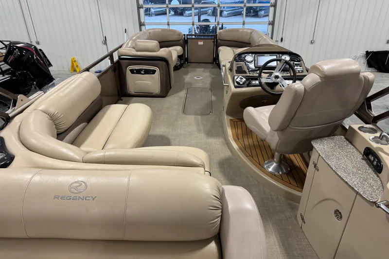 Slide: The Image of 2015 Sun Tracker Regency 254 XP3 pontoon boat interior with beige seating and helm. - 7