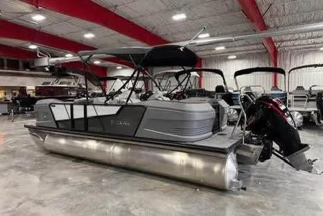 Slide: The Image of 2025 Sylvan A-22 pontoon boat in showroom, featuring sleek design and modern outboard motor. - 4