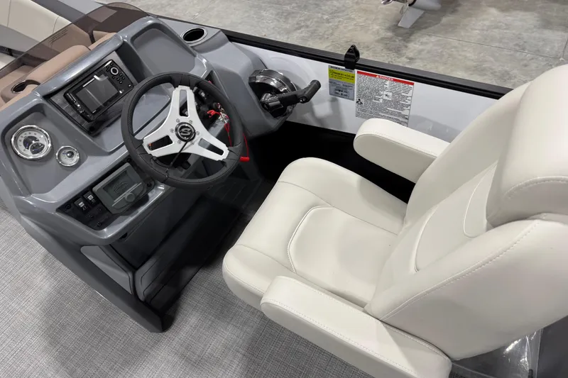 Slide: The Image of 2025 Sylvan A-22 boat cockpit with steering wheel and white captain's chair. - 10
