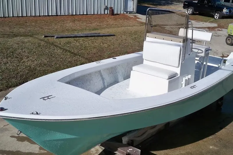 Slide: The Image of 2026 C-Hawk 23 Center Console boat with white seating and teal hull. - 2