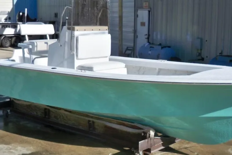 Slide: The Image of 2026 C-Hawk 23 Center Console boat with teal hull, docked outdoors. - 3