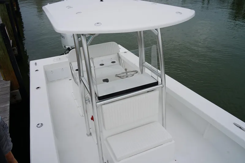 Slide: The Image of 2026 C-Hawk 25 Center Console boat with sleek design, docked on calm water. - 10