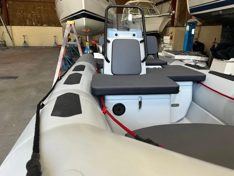 Slide: The Image of 2025 Zodiac Open 4.2 inflatable boat in a storage facility, featuring seating and control console. - 3