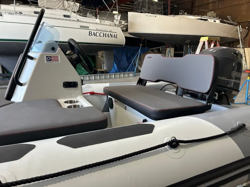 Slide: The Image of 2025 Zodiac Open 4.2 inflatable boat with seating, in a marina setting. - 6
