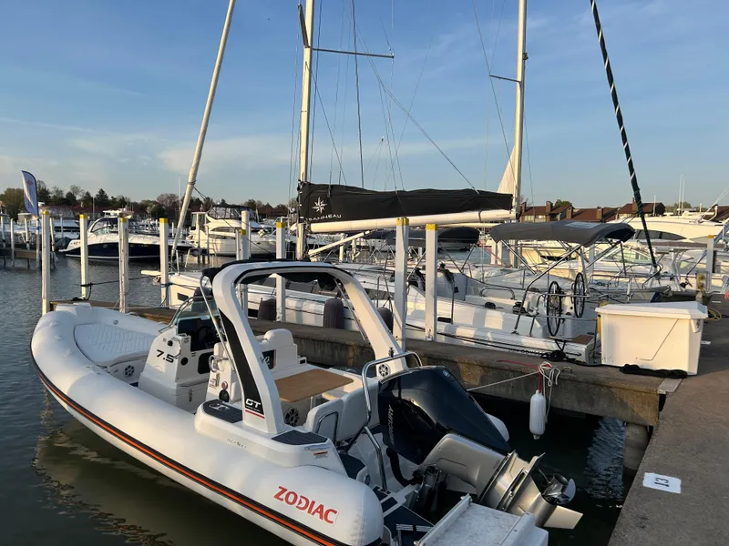 Slide: The Image of 2025 Zodiac Medline 7.5 GT boat docked at marina with sailboats in background. - 1