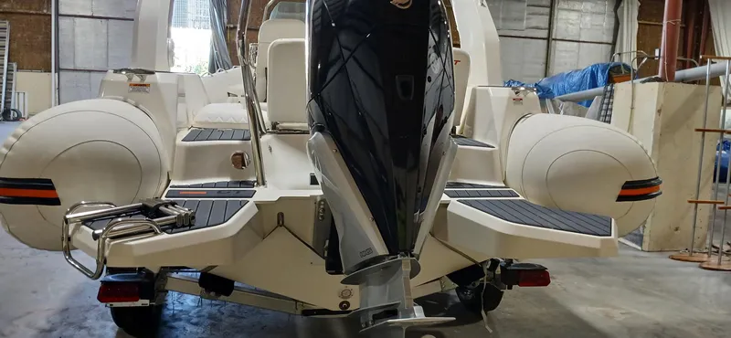 Slide: The Image of 2025 Zodiac Medline 7.5 GT boat in a warehouse, showcasing rear view and engine. - 13