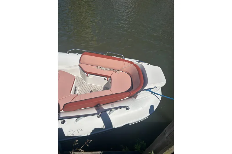 Slide: The Image of 2026 Zodiac Medline 9 boat with red seating, docked on calm water. - 11