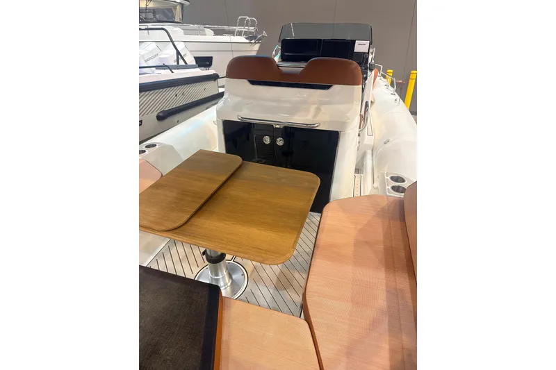 Slide: The Image of 2025 Zodiac Medline 9 boat interior with wooden table and seating area. - 7