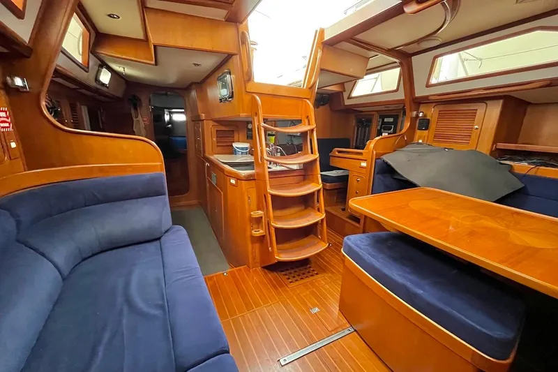 Slide: The Image of Luxurious 2004 Hylas 49 yacht interior with wooden finish and blue seating. - 10