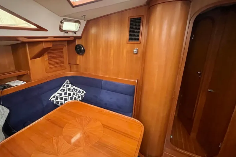 Slide: The Image of Interior of 2004 Hylas 49 yacht with wooden paneling and blue cushioned seating. - 16