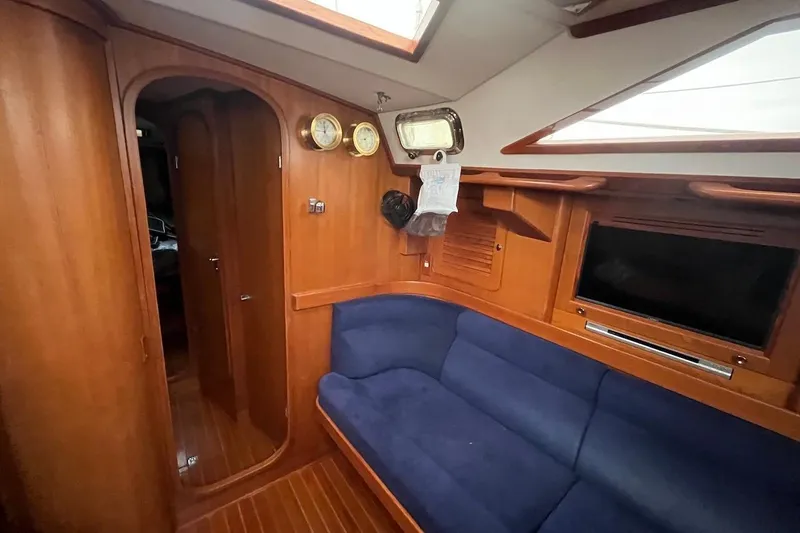 Slide: The Image of Interior of 2004 Hylas 49 yacht with blue seating and wooden finish. - 17