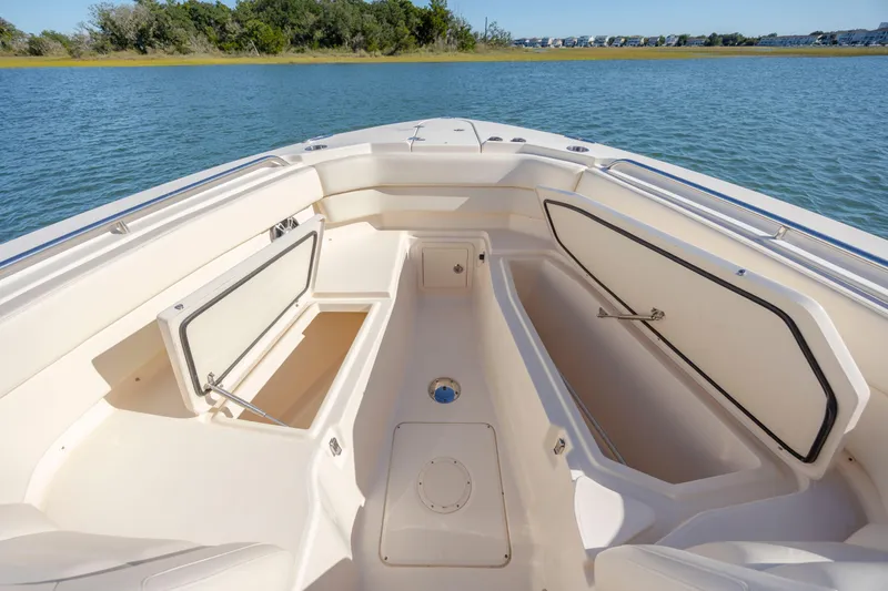 Slide: The Image of 2020 Grady-White Freedom 307 boat interior with open storage compartments on calm water. - 11