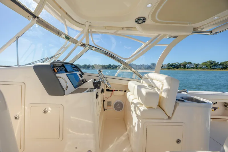 Slide: The Image of 2020 Grady-White Freedom 307 boat interior with helm, luxurious seating, and scenic water view. - 19
