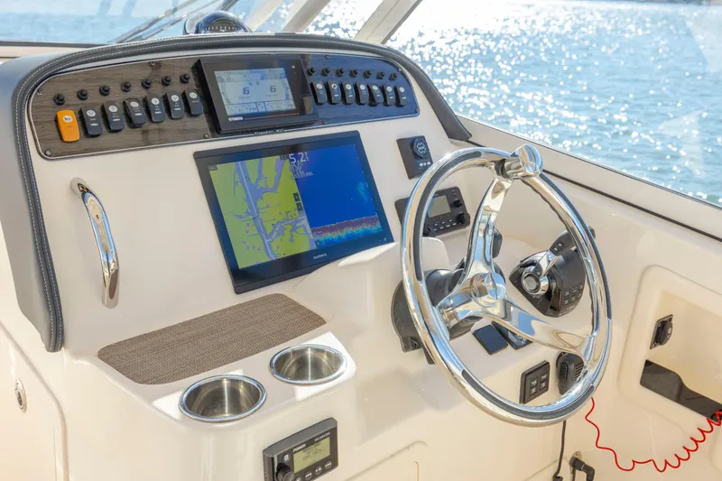 Slide: The Image of 2020 Grady-White Freedom 307 boat dashboard with navigation screens and steering wheel. - 21