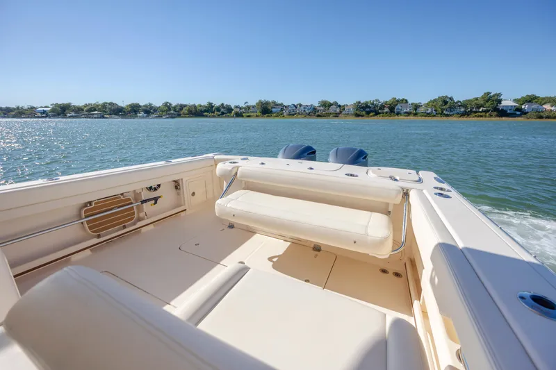 Slide: The Image of 2020 Grady-White Freedom 307 boat on calm water, featuring spacious seating and dual engines. - 26
