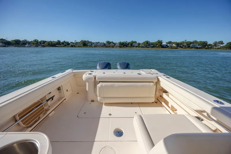 Slide: The Image of 2020 Grady-White Freedom 307 boat on calm water, showcasing spacious deck and seating. - 28