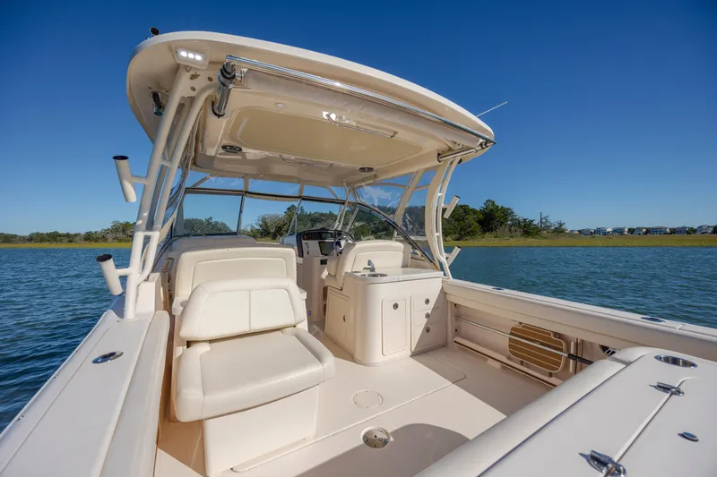Slide: The Image of 2020 Grady-White Freedom 307 boat interior with seating and helm, on calm water. - 36