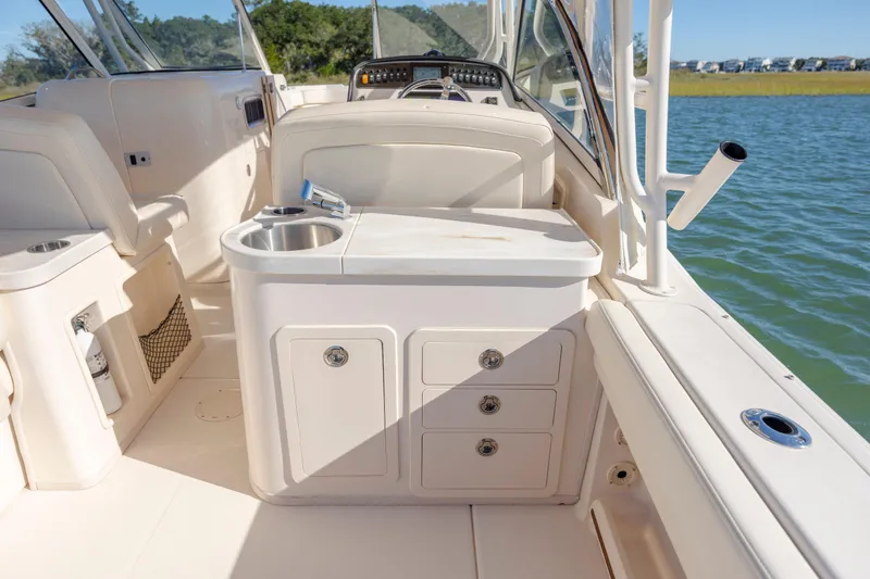 Slide: The Image of 2020 Grady-White Freedom 307 boat interior with sink and storage, on calm water. - 39