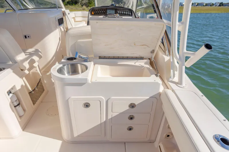 Slide: The Image of 2020 Grady-White Freedom 307 boat interior with sink, storage, and open compartment by the water. - 40