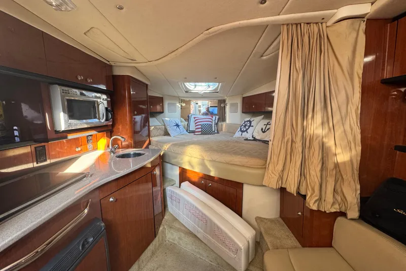Slide: The Image of 2007 Sea Ray Sundancer 310 cabin interior with kitchenette and cozy sleeping area. - 10