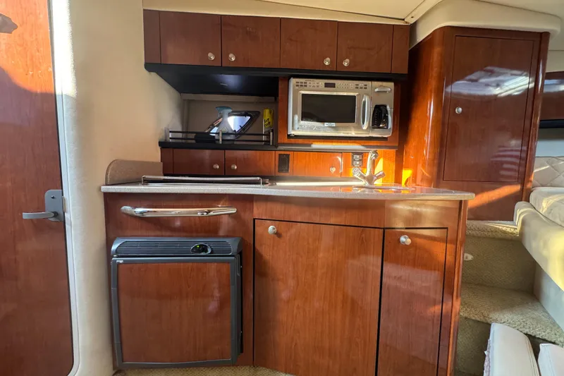 Slide: The Image of 2007 Sea Ray Sundancer 310 interior kitchen with wood cabinetry and modern appliances. - 13