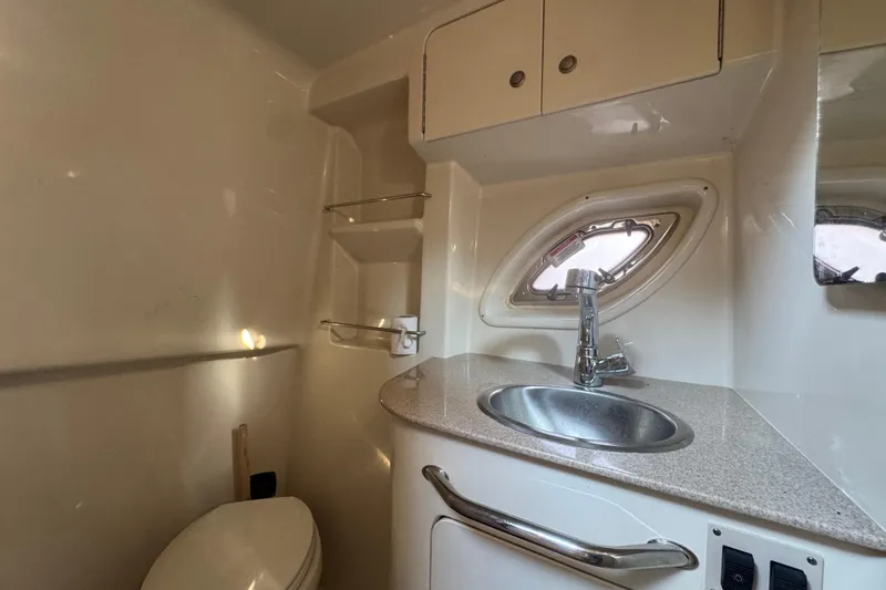 Slide: The Image of 2007 Sea Ray Sundancer 310 bathroom with sink, toilet, and porthole window. - 20