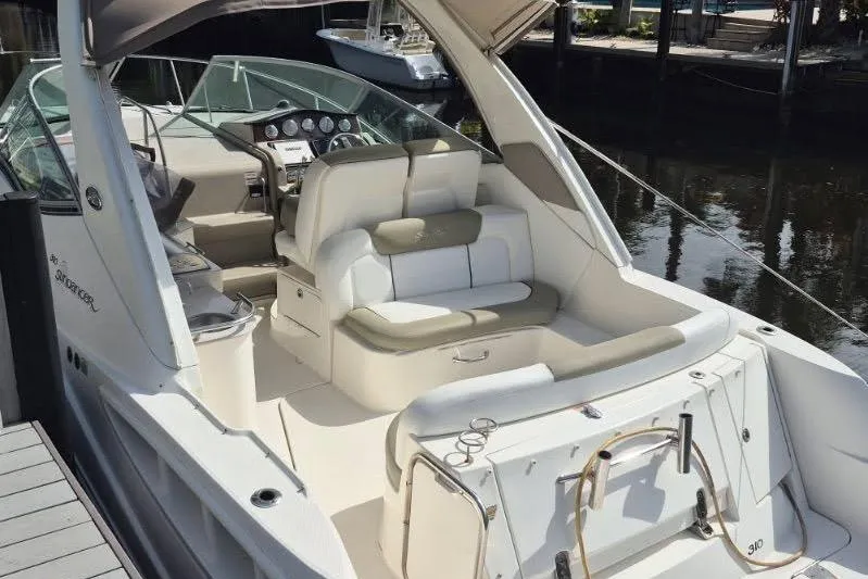 Slide: The Image of 2007 Sea Ray Sundancer 310 boat interior with seating and dashboard, docked by the water. - 24