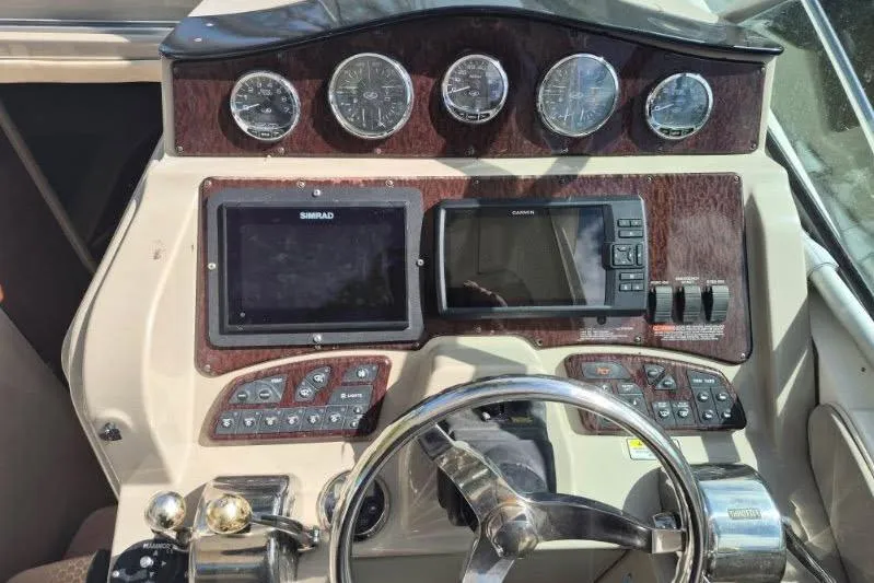 Slide: The Image of 2007 Sea Ray Sundancer 310 dashboard with gauges, navigation screens, and steering wheel. - 33