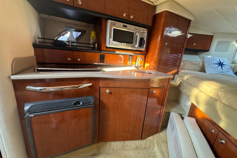 Slide: The Image of 2007 Sea Ray Sundancer 310 interior with kitchenette, microwave, and cozy sleeping area. - 41