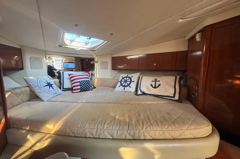 Slide: The Image of 2007 Sea Ray Sundancer 310 cabin interior with nautical-themed pillows and skylight. - 44