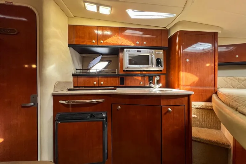 Slide: The Image of Luxurious 2007 Sea Ray Sundancer 310 yacht interior with kitchenette and wood cabinetry. - 54