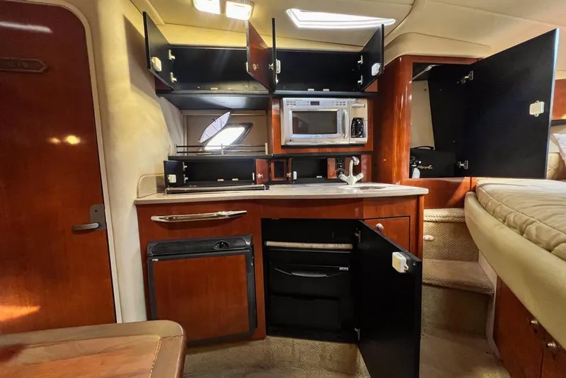 Slide: The Image of 2007 Sea Ray Sundancer 310 interior kitchen with open cabinets and appliances. - 55