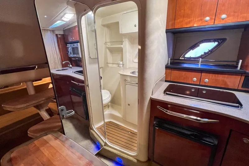 Slide: The Image of 2007 Sea Ray Sundancer 310 interior with kitchenette, dining area, and compact bathroom. - 63