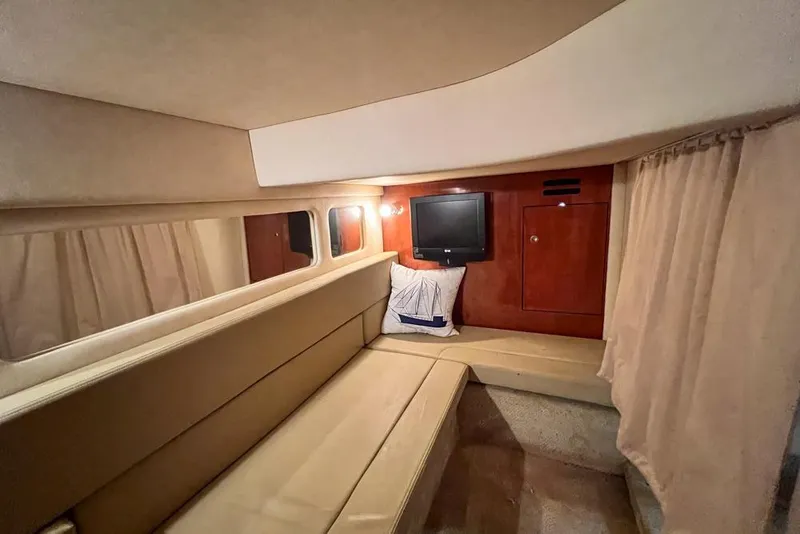 Slide: The Image of 2007 Sea Ray Sundancer 310 cabin interior with seating, TV, and nautical decor. - 69