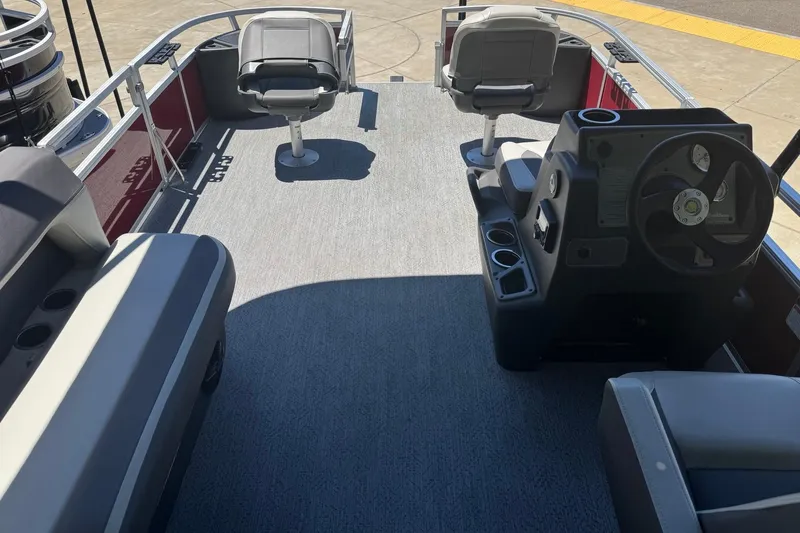 Slide: The Image of 2026 Sun Tracker Bass Buggy 18 DLX pontoon boat interior with seating and steering console. - 7