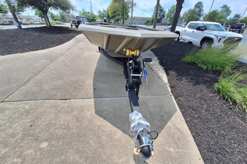 Slide: The Image of 2026 Tracker Grizzly 1648 Utility boat on trailer, parked on a concrete path. - 2