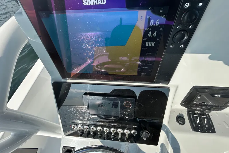 Slide: The Image of 2020 Sea Pro 248 Bay boat dashboard with Simrad navigation display and controls. - 8