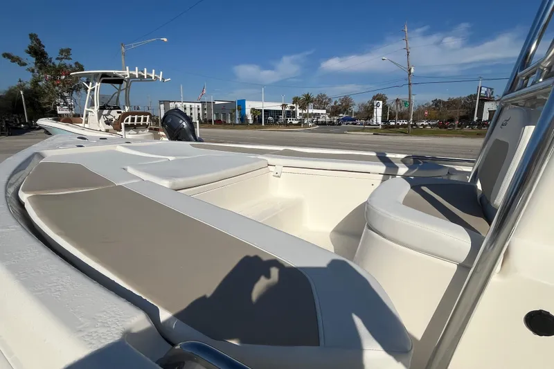 Slide: The Image of 2026 Bulls Bay 2200 boat interior with seating, parked outdoors under clear blue sky. - 16