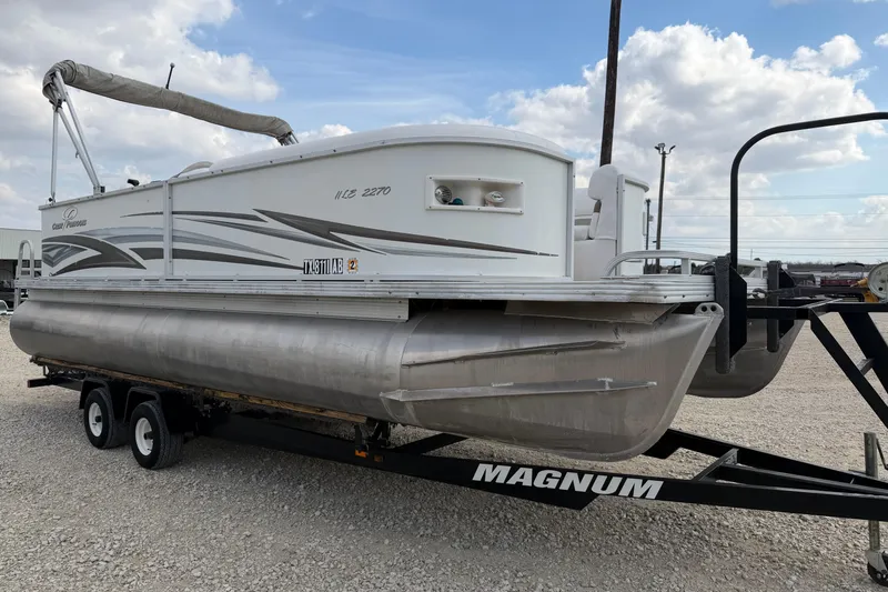 Slide: The Image of 2006 Crest II LE 2270 pontoon boat on a Magnum trailer, parked on gravel. - 4