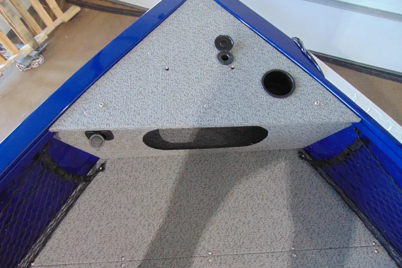 Slide: The Image of Interior view of 2026 Crestliner 1850 Kodiak WT boat, featuring carpeted storage area. - 13