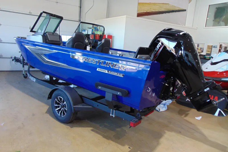 Slide: The Image of 2026 Crestliner 1850 Kodiak WT boat in showroom, blue exterior, on trailer. - 3