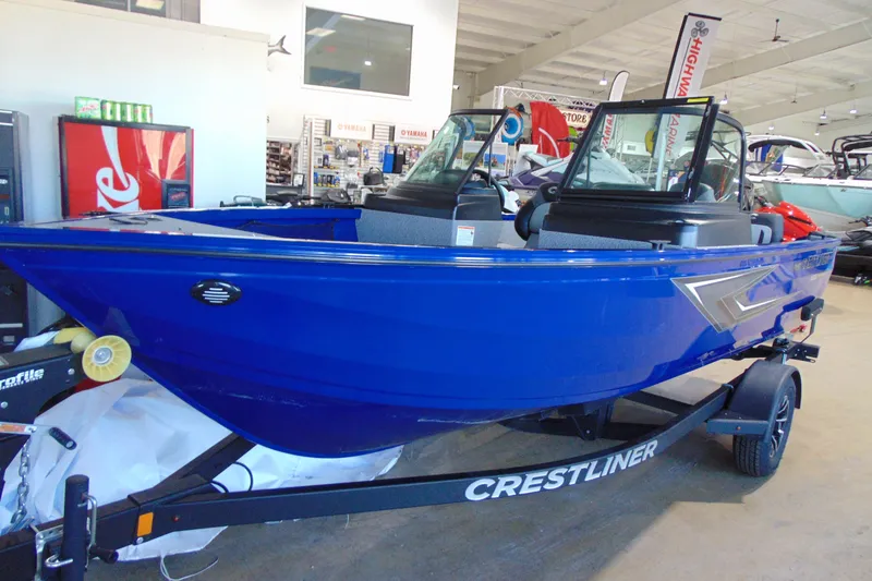 Slide: The Image of 2026 Crestliner 1850 Kodiak WT boat in showroom, vibrant blue color, on trailer. - 4