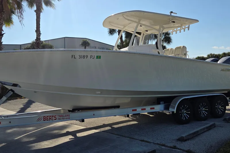 The Image of 2015 Jupiter 30 FS boat on trailer, parked outdoors under clear sky. - 0